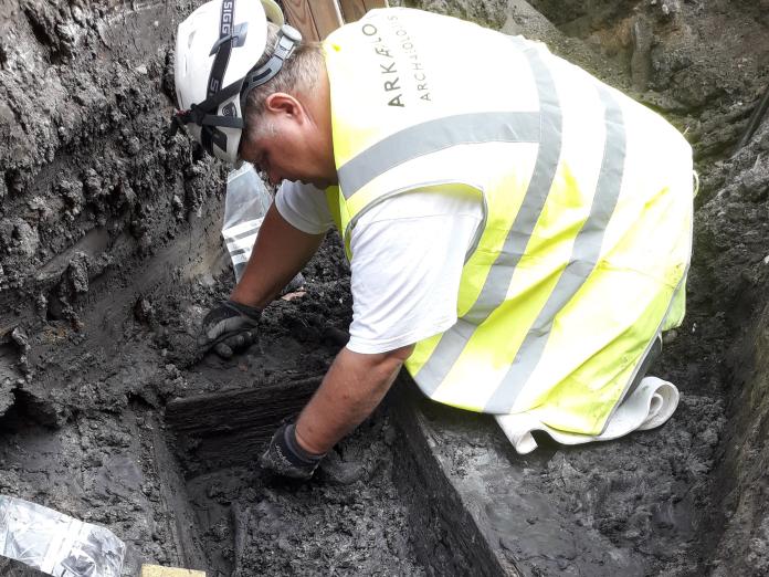 Arkæolog udgraver kiste og skelet