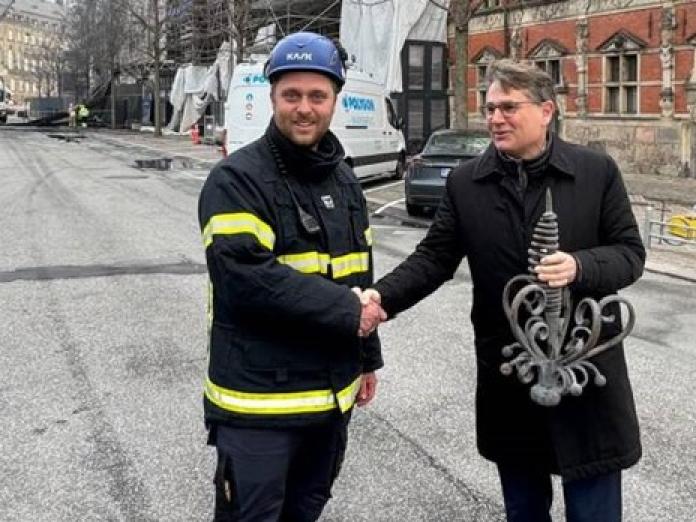 Brian Mikkelsen får overrakt den genfundne del af fløjstangen af en vagtmester ved Børsen. 