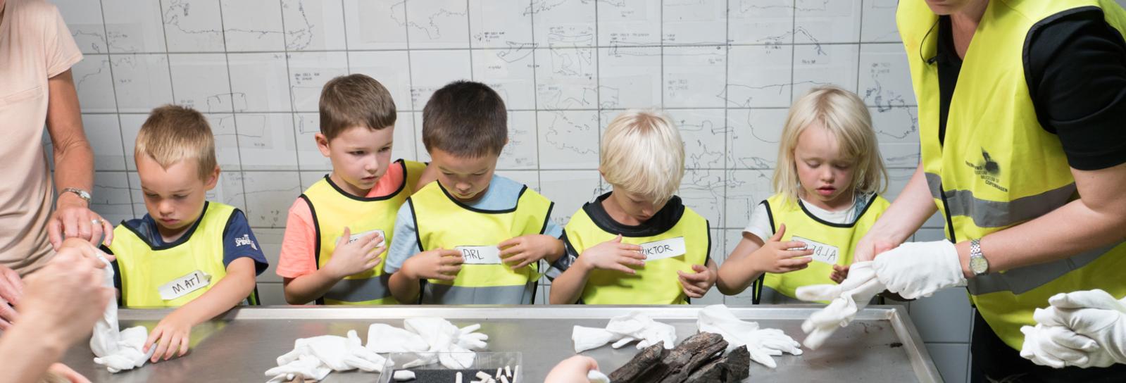 Dagtilbudsbørn undersøger arkæologiske fund i museets fundkælder
